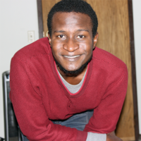 Saddiq Dzukogi smiles, wearing a red shirt